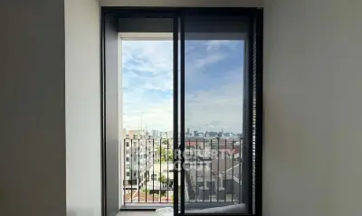 Modern apartment with stunning city view from large balcony window, perfect for urban living.