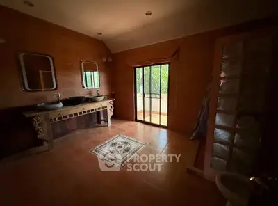 Spacious bathroom with dual sinks and balcony access in elegant home.