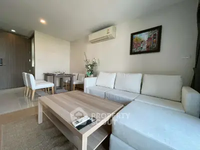 Modern living room with cozy white sofa and dining area in stylish apartment