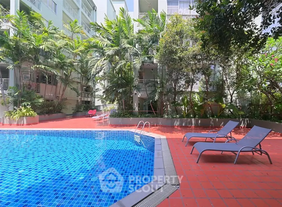 Luxurious outdoor pool area with lush greenery and modern lounge chairs.