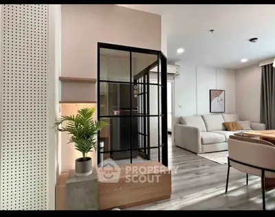 Modern living room with stylish decor and glass partition, featuring cozy seating and elegant flooring.