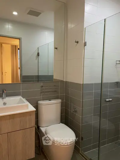 Modern bathroom with sleek design, featuring a glass shower and stylish vanity.