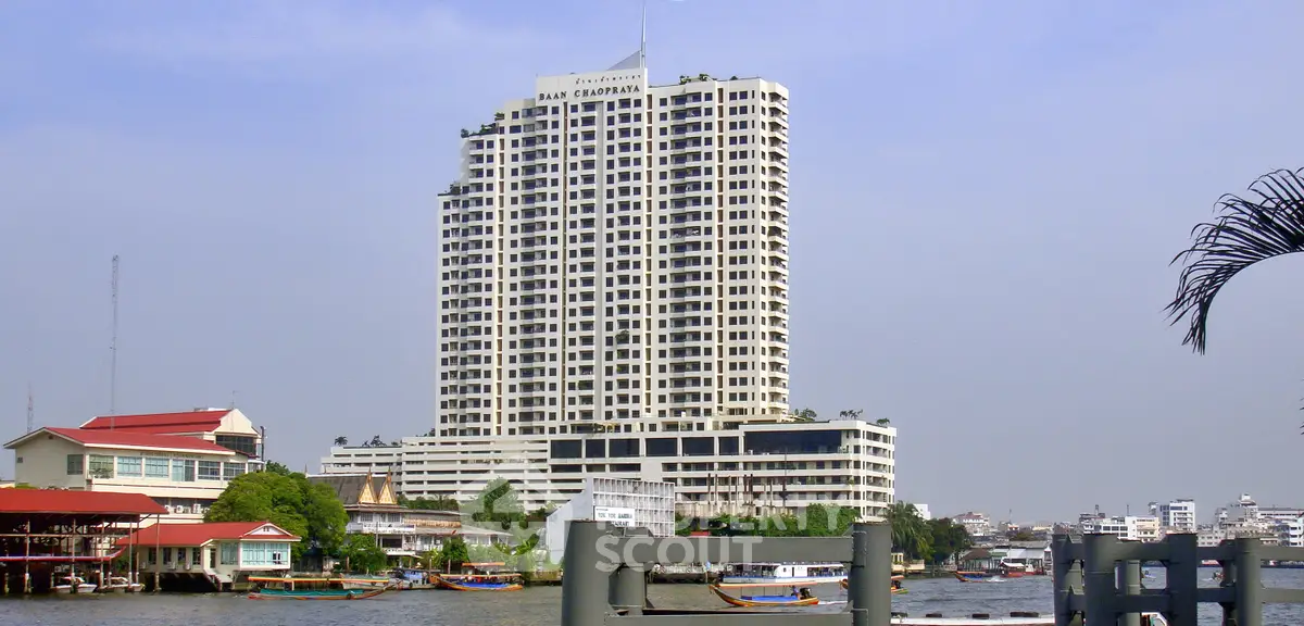 Stunning riverside high-rise building with panoramic city views and lush surroundings.