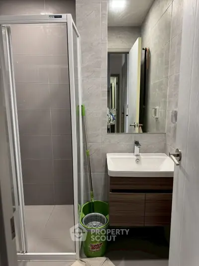Modern bathroom with sleek shower and stylish vanity in contemporary design.