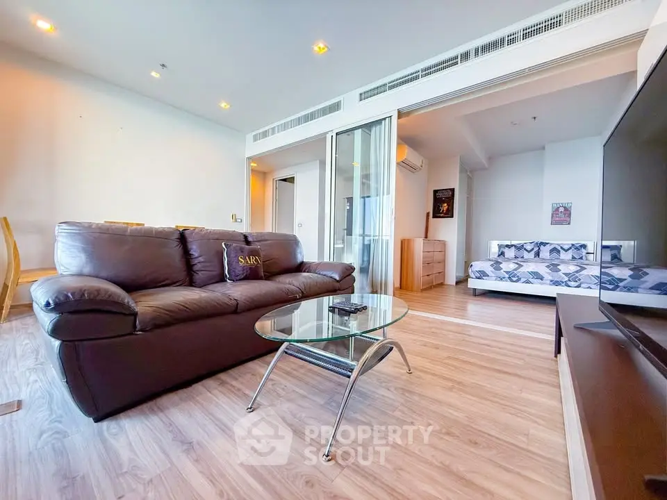 Spacious living room with modern decor and cozy seating in a stylish apartment.