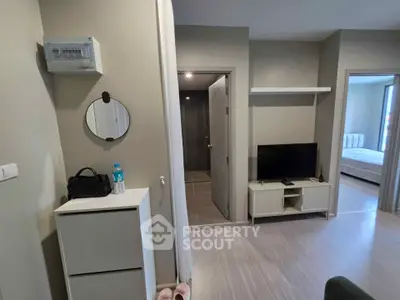 Modern apartment interior with TV, storage, and bedroom view