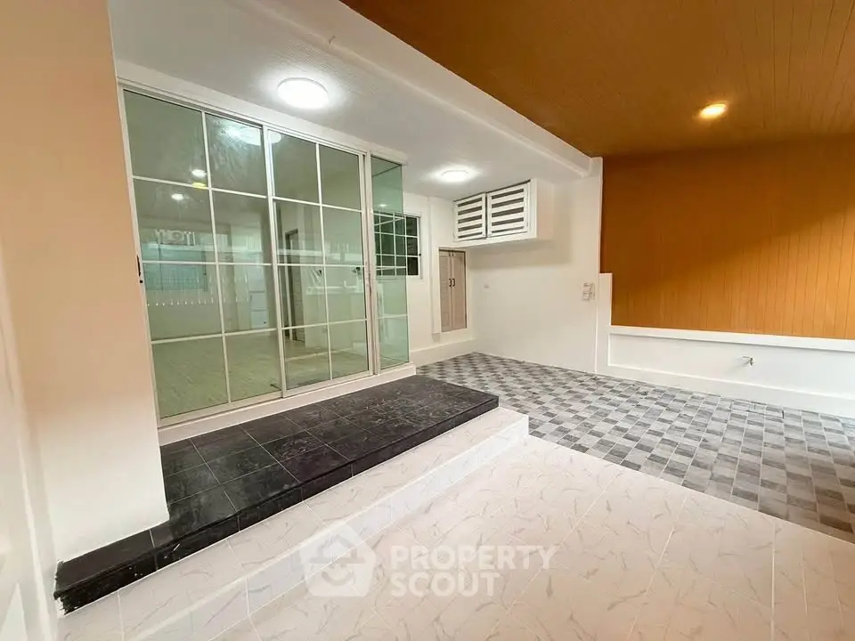 Spacious modern interior with stylish flooring and sliding glass doors, perfect for versatile living spaces.