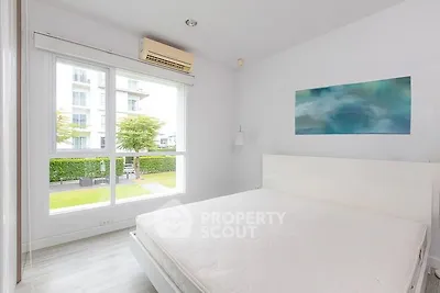 Bright and airy bedroom with large window and modern decor in a contemporary apartment.