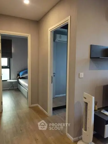 Cozy and modern studio apartment with sleek wooden flooring, a comfortable bed, and ample natural light, perfect for singles or couples.