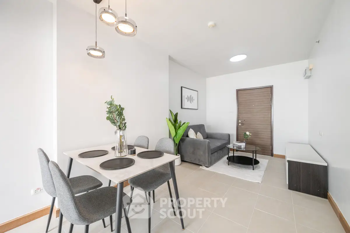 Modern living room with dining area, featuring stylish furniture and contemporary decor.