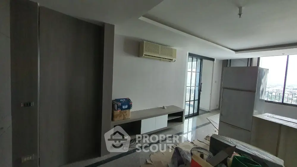 Spacious living room with modern design and large windows offering city views