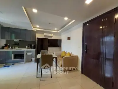 Modern open-layout living room with kitchen, dining area, and cozy seating in a stylish apartment.