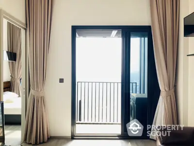 Elegant bedroom with floor-to-ceiling windows leading to a sunlit balcony, offering a serene retreat with a hint of luxury living.