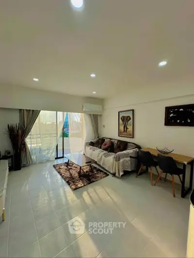 Spacious living room with modern decor and natural light in a stylish apartment.