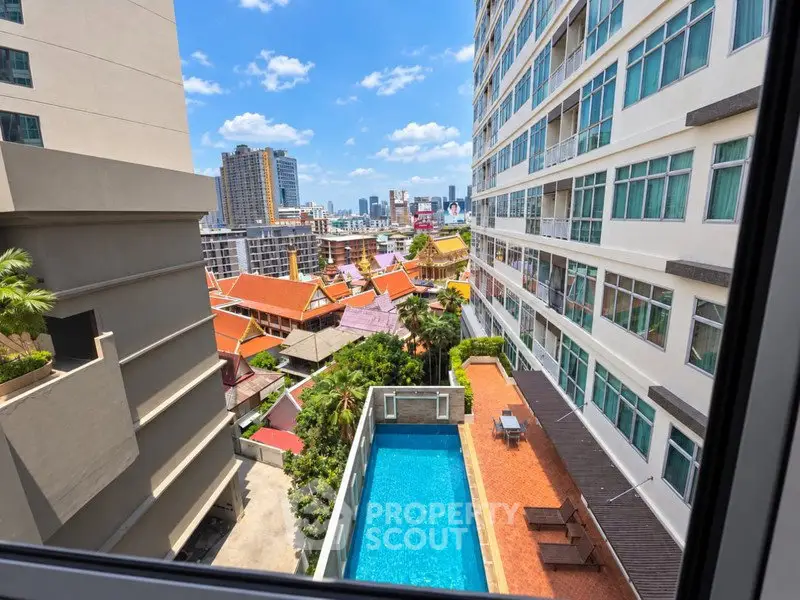 Stunning cityscape view from high-rise building with pool and vibrant architecture.