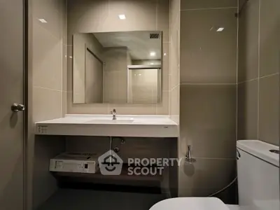 Modern bathroom with sleek fixtures and large mirror in contemporary apartment.