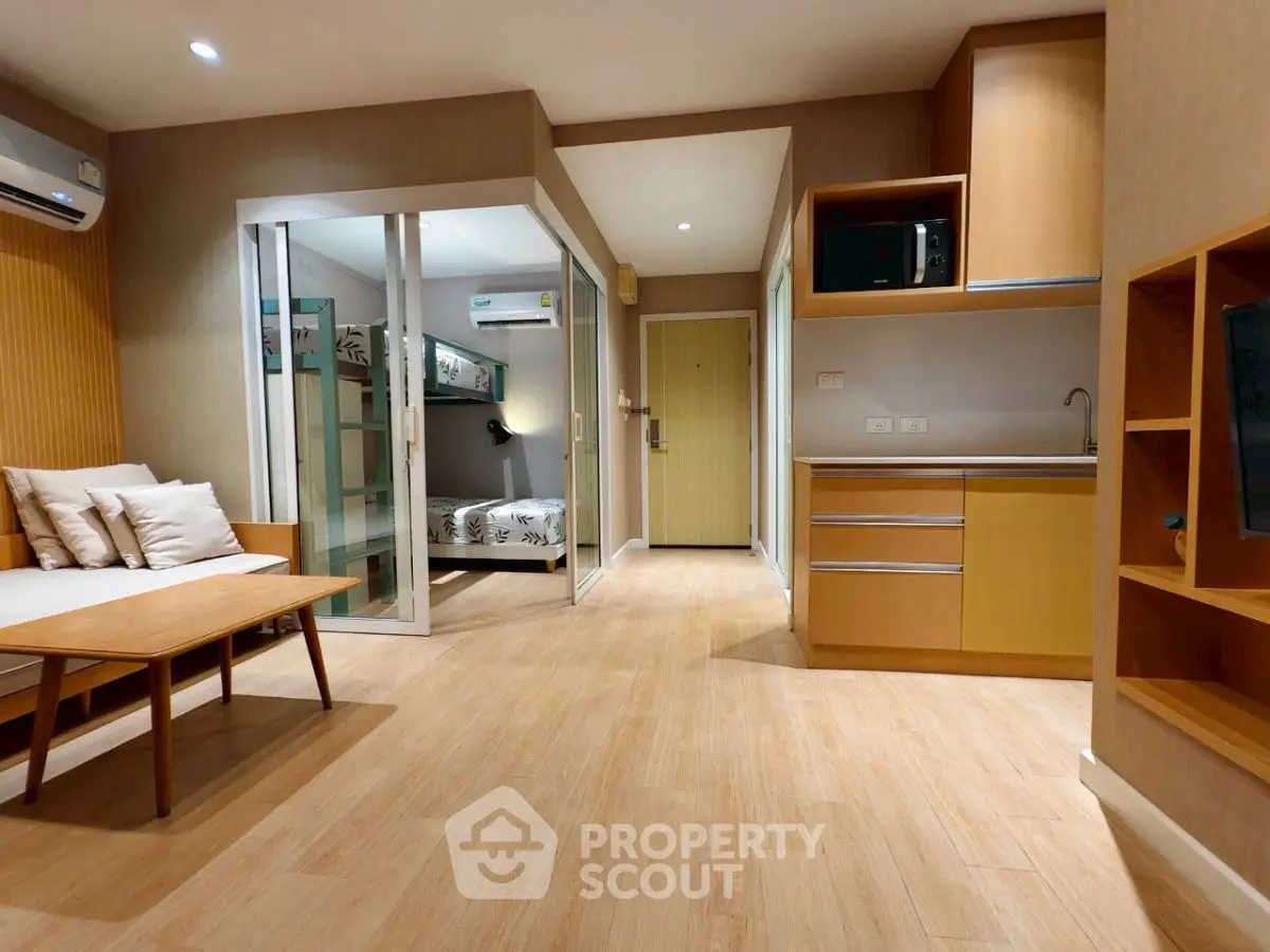 Modern studio apartment with cozy living area and compact kitchen