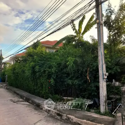 Charming suburban house with lush greenery and red-tiled roof, perfect for serene living.