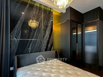Luxurious bedroom with elegant black marble accent wall and modern chandelier lighting.