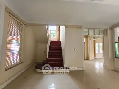 Spacious interior with elegant staircase and natural light, perfect for modern living.