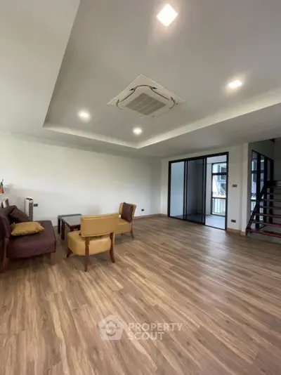 Spacious modern living room with wooden flooring and ceiling air conditioning
