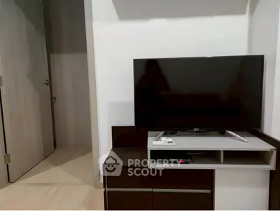 Modern living room with sleek TV stand and flat-screen TV, minimalist design.