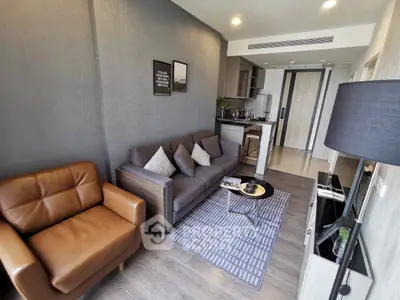 Modern living room with stylish furniture and open kitchen layout in a contemporary apartment.