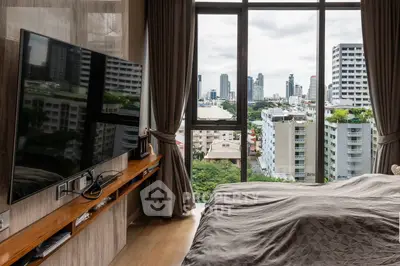 Luxurious bedroom with stunning city view and modern amenities in high-rise apartment.
