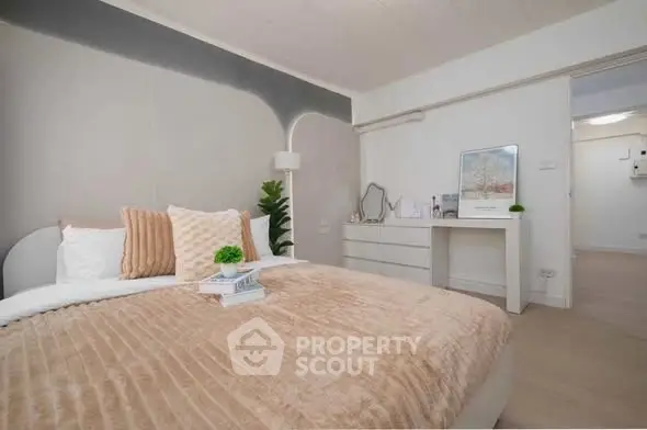 Cozy bedroom with modern decor and plush bedding in a stylish apartment.