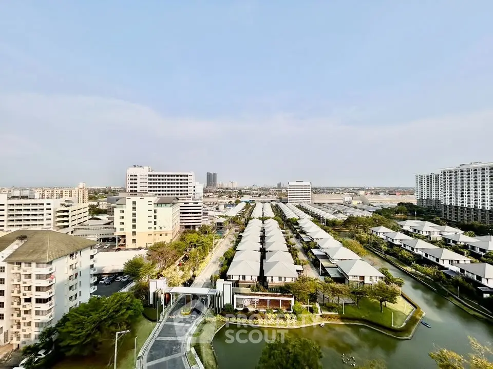 Stunning aerial view of modern residential complex with lush greenery and water features, perfect for urban living.