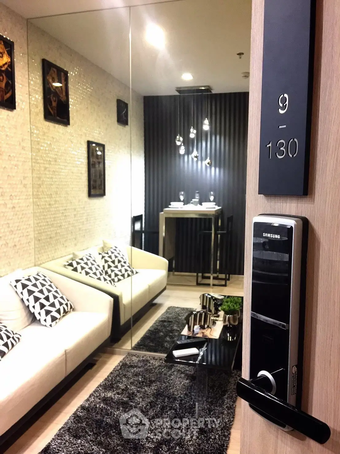 Modern living room with sleek decor and digital door lock, showcasing contemporary style.