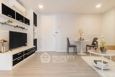 Modern living room with sleek black and white decor, featuring a cozy seating area and stylish shelving.