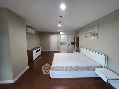 Spacious modern bedroom with sleek wooden flooring and minimalist decor