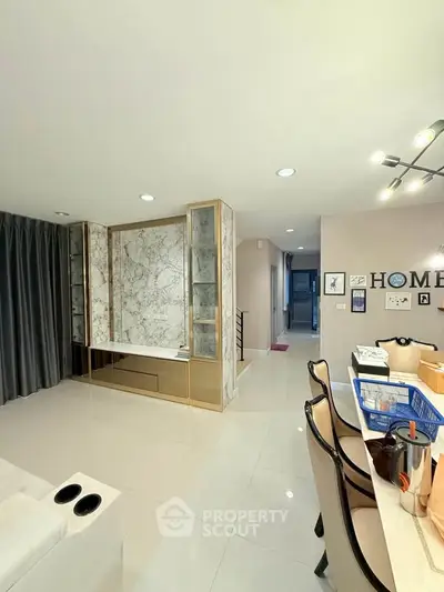 Modern living room with elegant marble accents and stylish dining area.