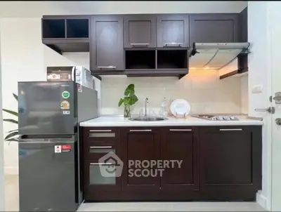 Modern kitchen with dark wood cabinets and stainless steel appliances