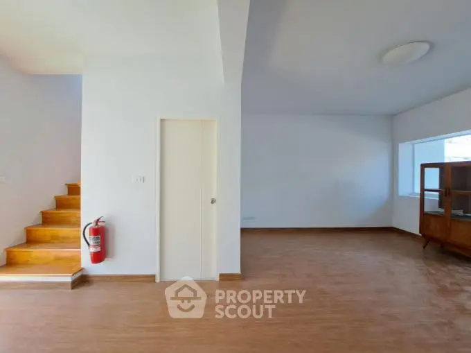 Spacious interior with wooden flooring and staircase, ideal for modern living.