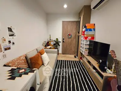 Cozy living room with modern decor, featuring a comfortable sofa, stylish rug, and wall-mounted TV unit.