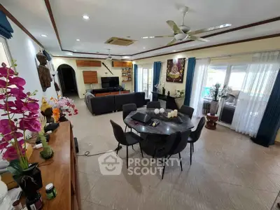 Spacious living room with modern decor, large windows, and elegant dining area.
