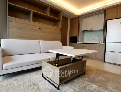 Modern living room with sleek furniture and open kitchen layout in a stylish apartment.