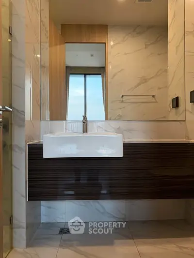 Modern bathroom with sleek vanity and large mirror in luxury apartment.