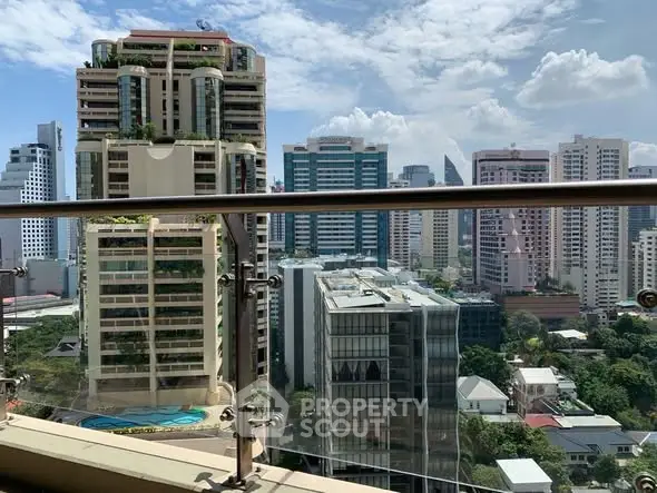 Stunning cityscape view from a high-rise balcony with modern skyscrapers and clear blue sky.
