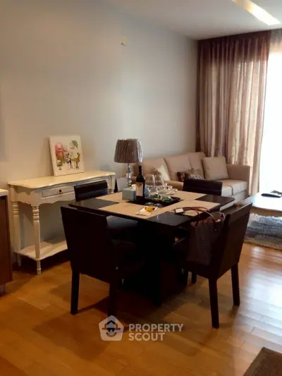 Elegant living room with dining area, featuring modern furniture and natural light.