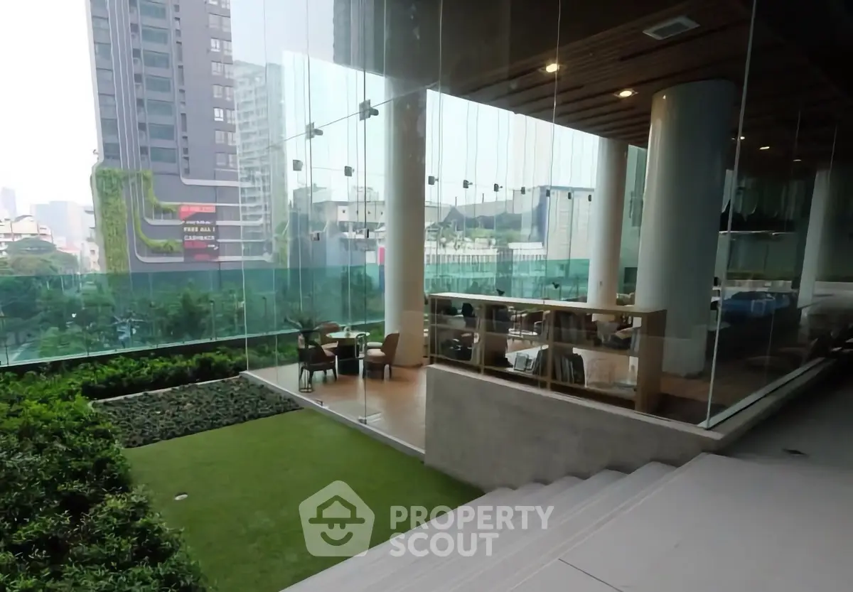 Modern building with glass walls and lush greenery in urban setting