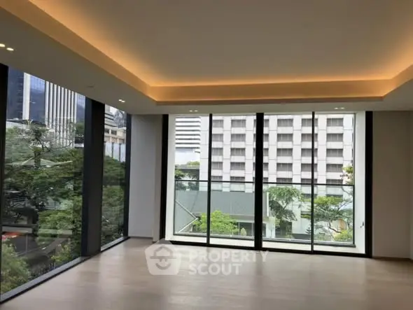 Spacious modern living room with floor-to-ceiling windows and city view.