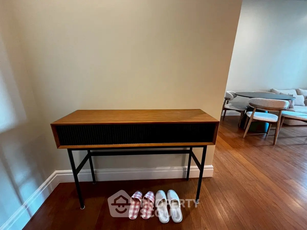 Stylish console table in modern living room with wooden flooring and cozy seating area.