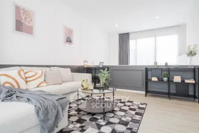 Modern living room with stylish decor and ample natural light, featuring a cozy sofa and chic coffee table.