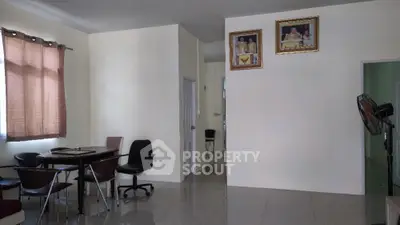 Spacious living room with tiled flooring, natural light from window with curtains, and a cozy dining area, perfect for family gatherings.