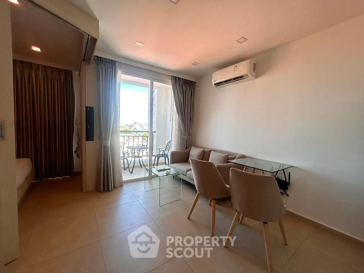 Modern living room with balcony view, featuring sleek furniture and air conditioning, perfect for urban living.