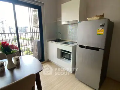 Modern kitchen with sleek appliances and balcony view in urban apartment