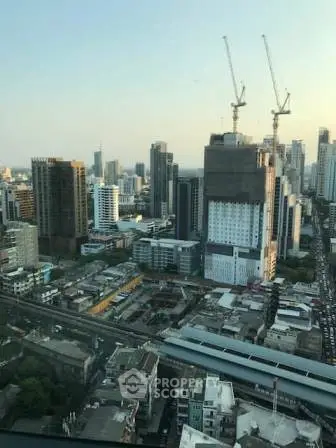 Stunning cityscape view from high-rise building showcasing urban skyline and construction cranes.